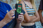 Hands holding a black block with green sticker on with the words 'Magenta Bats' 