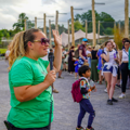 Keeper in green uniform holds a microphone while talking to a crowd at Summerset Safari 