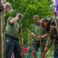 3 staff members hold wooden sticks ready to assemble keyhole garden