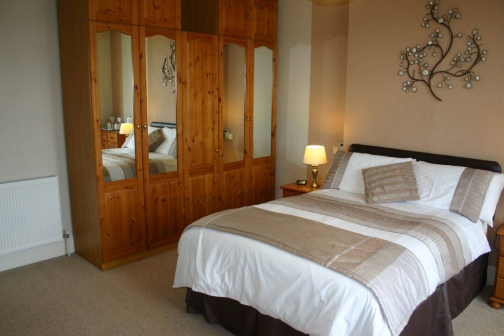 A double bed with a large mirrored wardrobe