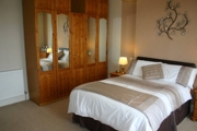A double bed with a large mirrored wardrobe