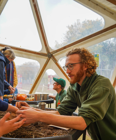 Male zoo staff making a seed ball in the education dome. 