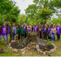 Ripple effect and Noah's Ark Zoo Farm staff members stand for a group photo in a woodland area behind their joint keyhole garden.